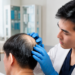Hair transplant consultation with a specialist examining scalp hair loss using digital scalp analysis to assess donor area and treatment suitability.