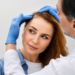 Hair restoration specialist examining a woman with visible crown thinning and a widened part line during a personalized hair loss consultation.
